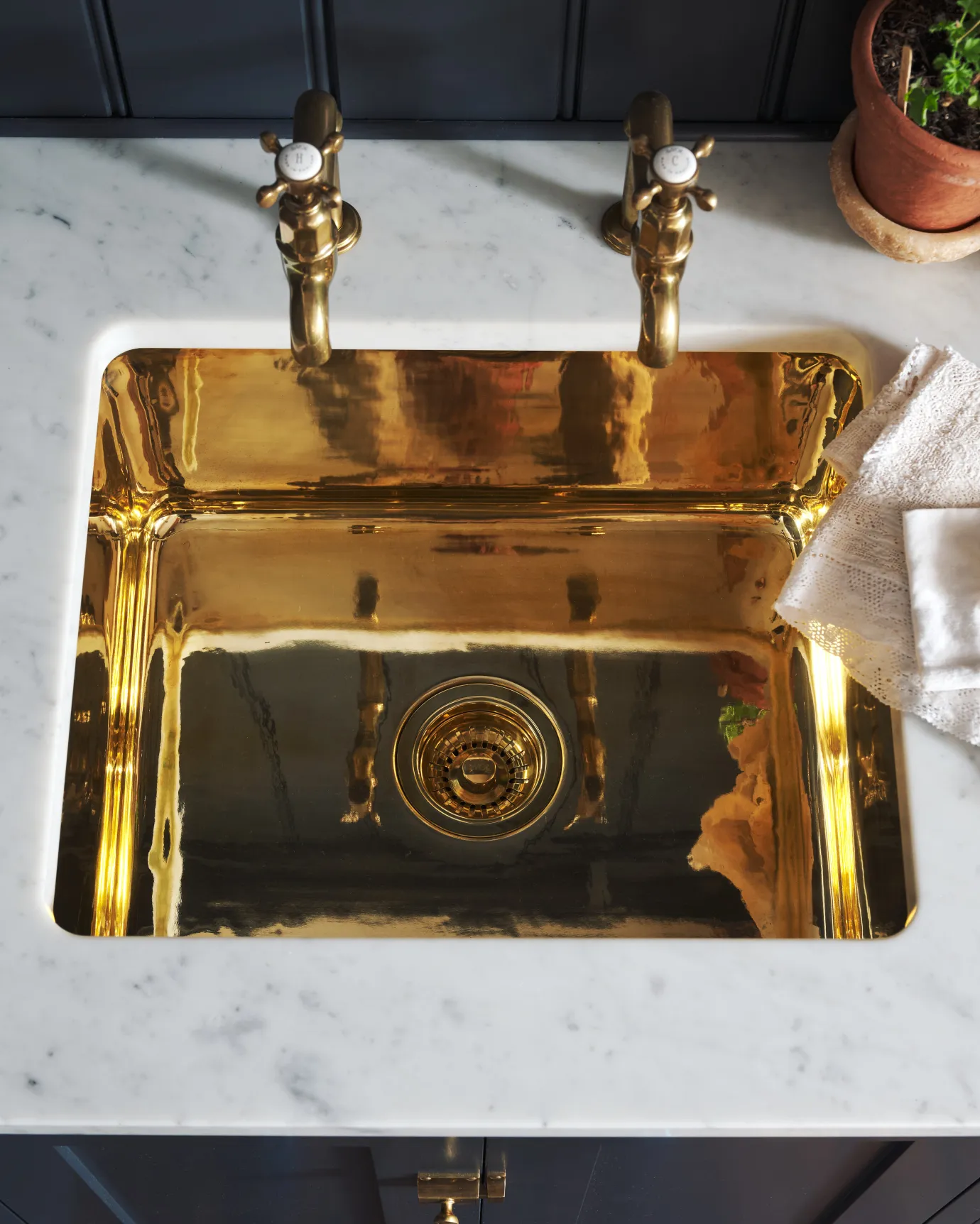 brass sink on a marble worktop