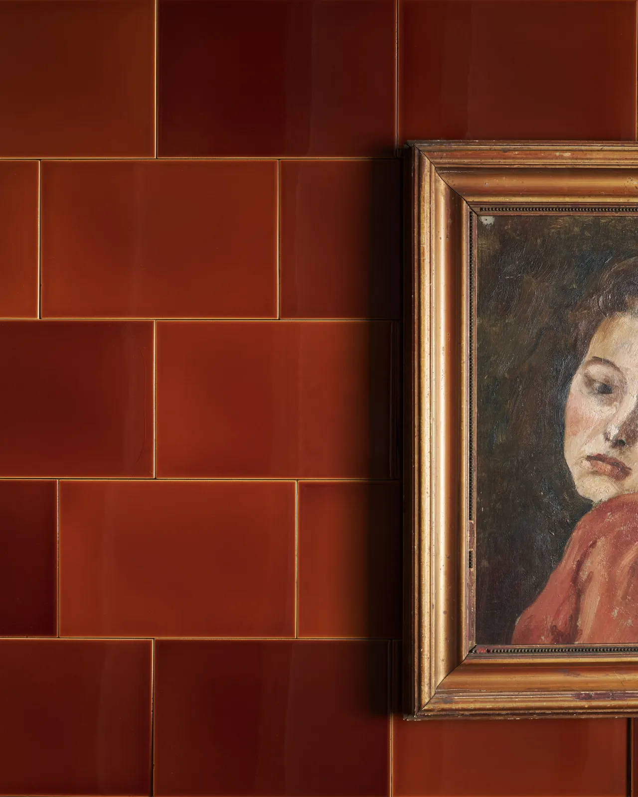 The Kentish brown tiles in various shades and an antique picture frame of a lady in front of the tiles