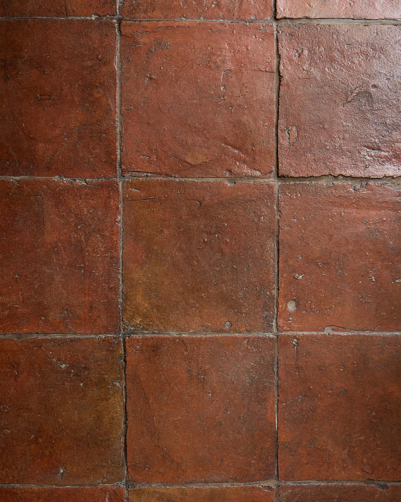 A flat lay image of the Terracotta Square tiles in the antique wax coating and mocha brown grout.